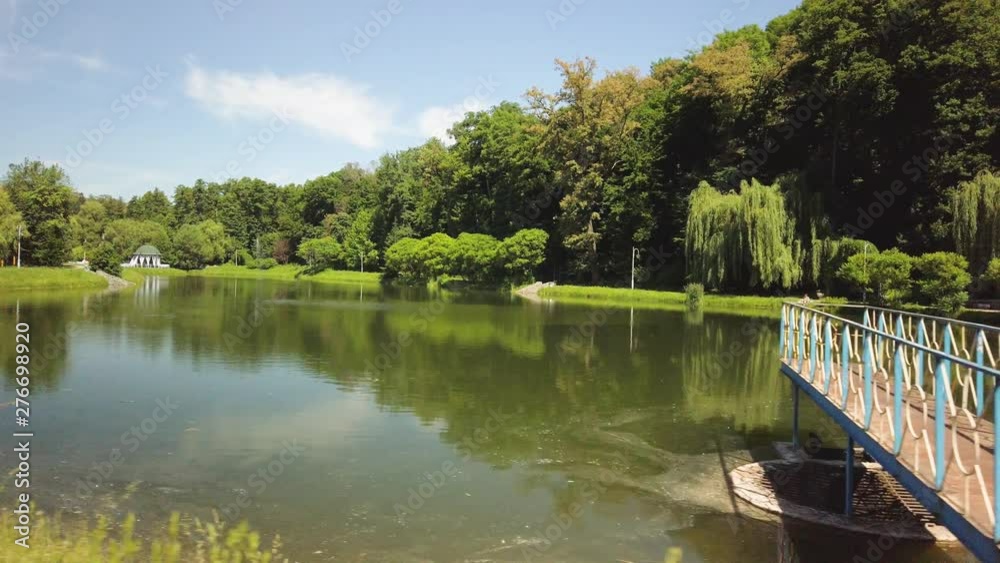 Tracking sliding shot of a pond lake in the middle of a park Tracking sliding shot of a pond lake in the middle of a park