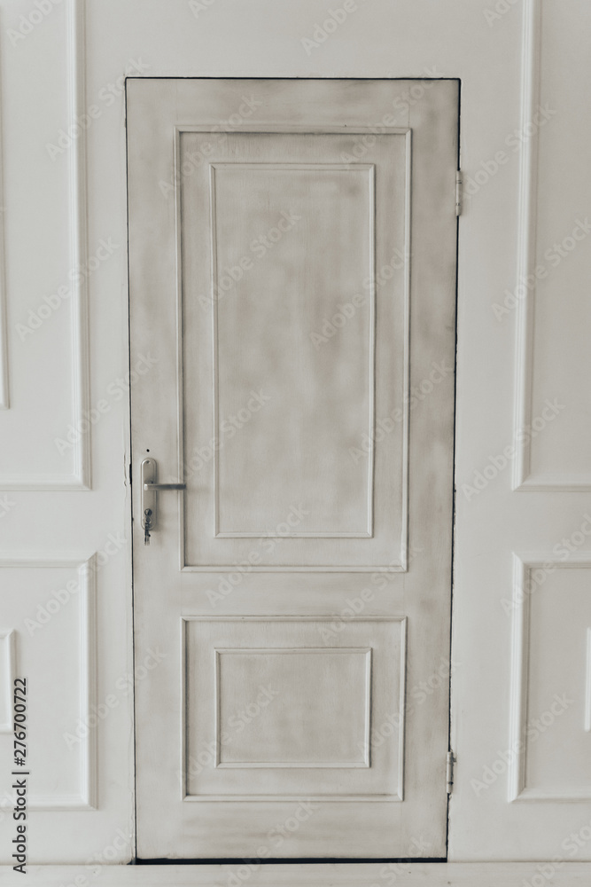 gray door on white wall background with keys in the lock
