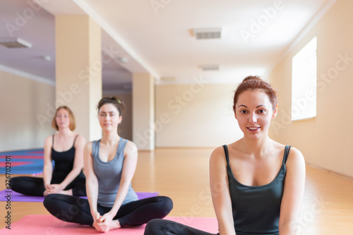 Young women do yoga in the classroom. The concept of sports lifestyle, health and spiritual balance