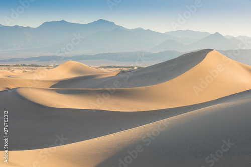 Early Morning Sunlight Over Sand Dunes And Mountains At Mesquite flat dunes  Death Valley National Park  California USA Stovepipe Wells sand dunes  very nice structures in sand Beautiful background