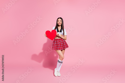 Full length body size view of her she nice-looking attractive lovely charming cheerful cheery straight-haired lady holding in hand large heart cardiology health care isolated on pink pastel background