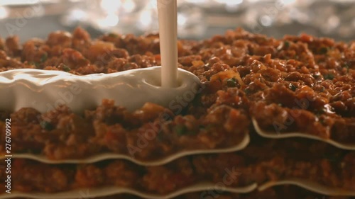 Tasty meat lasagne is poured with white creamy béchamel sauce. Very beautiful studio shot. Slow motion. Camera Phantom Flex 4K.
