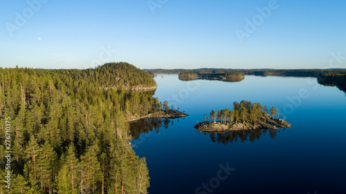  Aerial panoramic view of beautiful calm lake at sunset surrounded by forests. Kolovesi National park, Finland