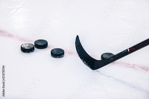 Ice Hockey Stick and Pucks on ice