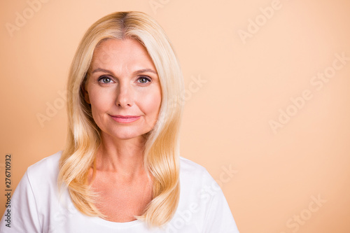 Close up photo of middle age lady pretty smiling neat appearance good-looking wear white casual t-shirt isolated pastel beige background