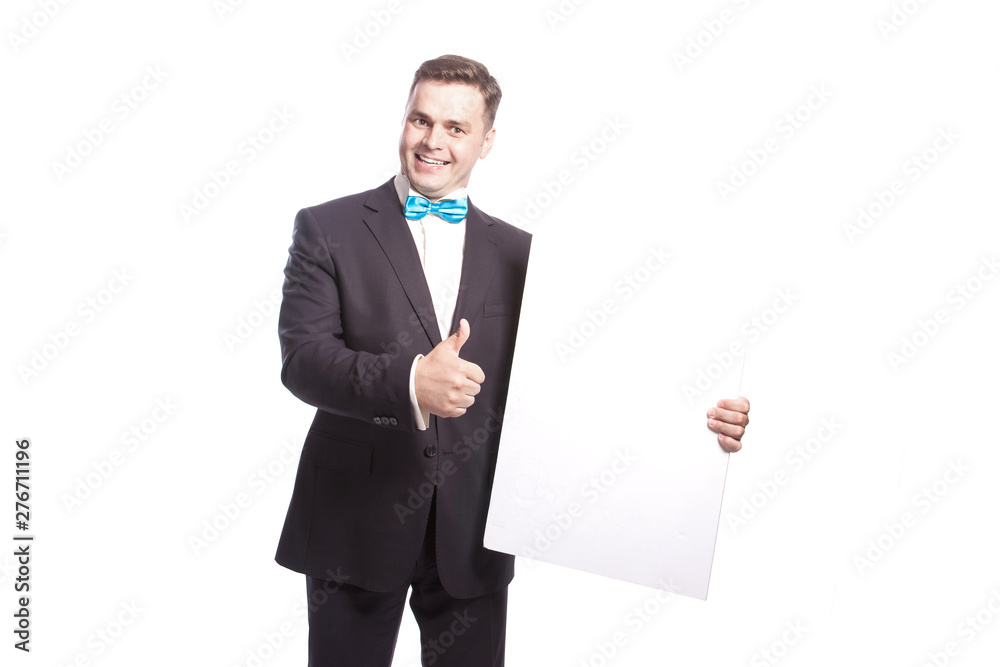 Smiling man in a suit shows thumb while holding a white sheet. Smiling man in a suit shows thumb while holding a white sheet.