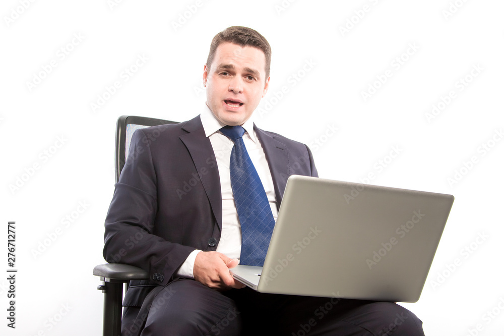Businessman sitting on a chair with a laptop in hand, talking. Businessman sitting on a chair with a laptop in hand, talking.