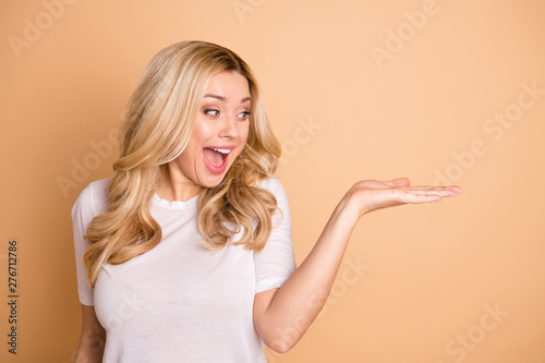 Close-up portrait of her she nice lovely charming cute attractive cheerful cheery wavy-haired lady holding good solution ad advert promotion isolated over beige pastel background