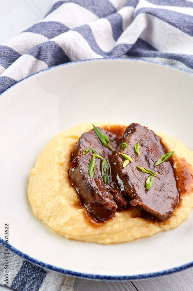 Pork Cheeks In Demiglas Sauce with mashed potatoes. Carrillada de cerdo in demi glace sauce. Traditional Spanish cuisine dish. vertical