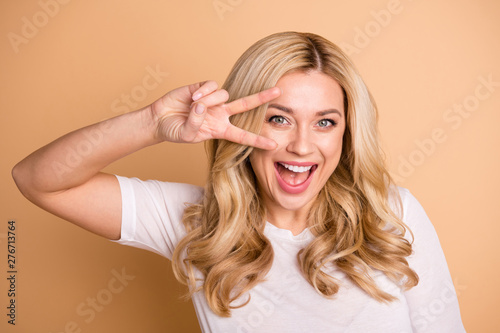 Close-up portrait of her she nice-looking attractive lovable lovely cheerful cheery glad funny wavy-haired lady showing v-sign celebrate isolated over beige pastel background