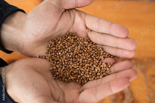 Hands holding buckwheat seeds, close-up