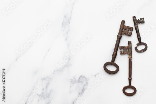 Vintage old fashioned keys on a marble background with copy space © ink drop