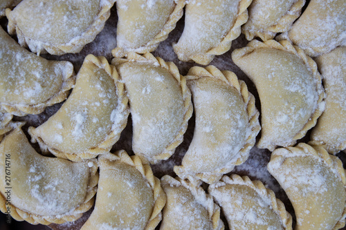 Vareniks are sprinkled with flour on the tray photo