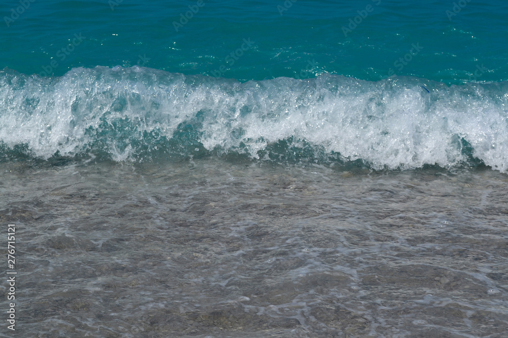 Fototapeta premium Sea water waves foam lapping to coastal shore