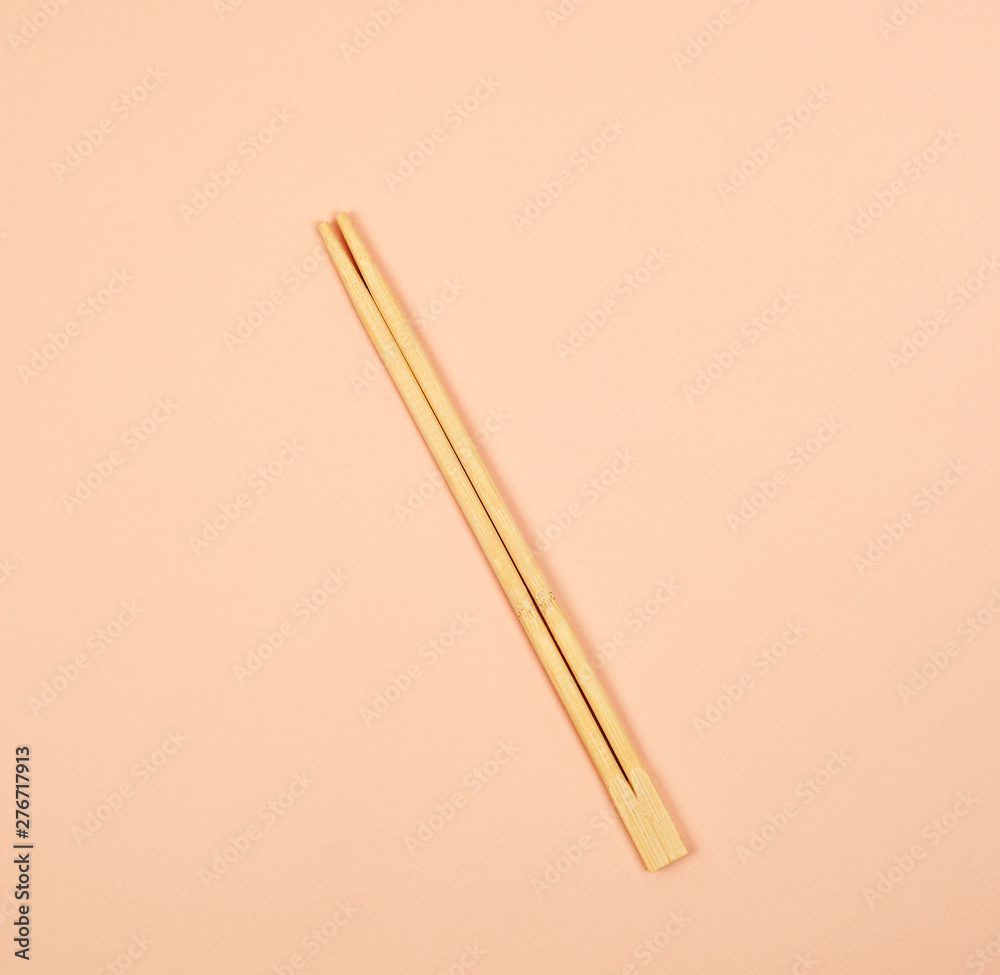 two wooden chopsticks on a beige background two wooden chopsticks on a beige background