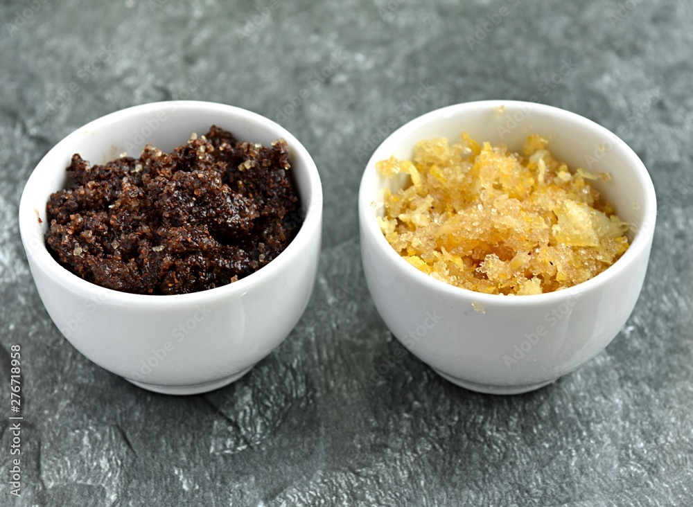 Two small bowls with homemade lip scrubs, with coffee and lemon peel.