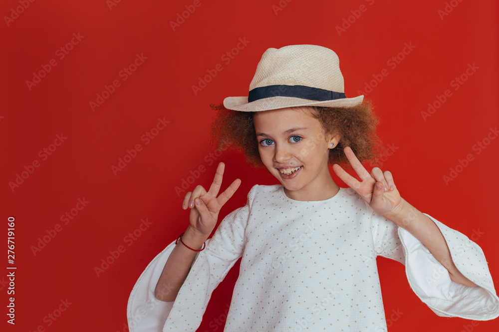Headshot Portrait of happy girl with curly hair smiling looking at camera. red background. Headshot Portrait of happy girl with curly hair smiling looking at camera. red background.
