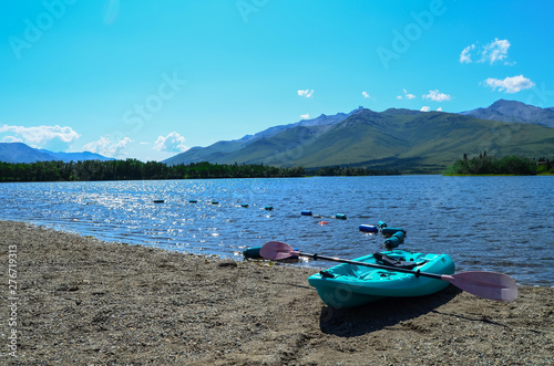 Blue kayak in front of Otto Lake in Healy with mountains in the background and blue sky above. Alaska, United States photo