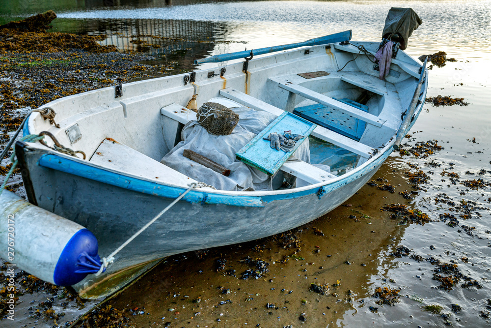 Old abandoned boat on the shore. Gloomy northern nature.