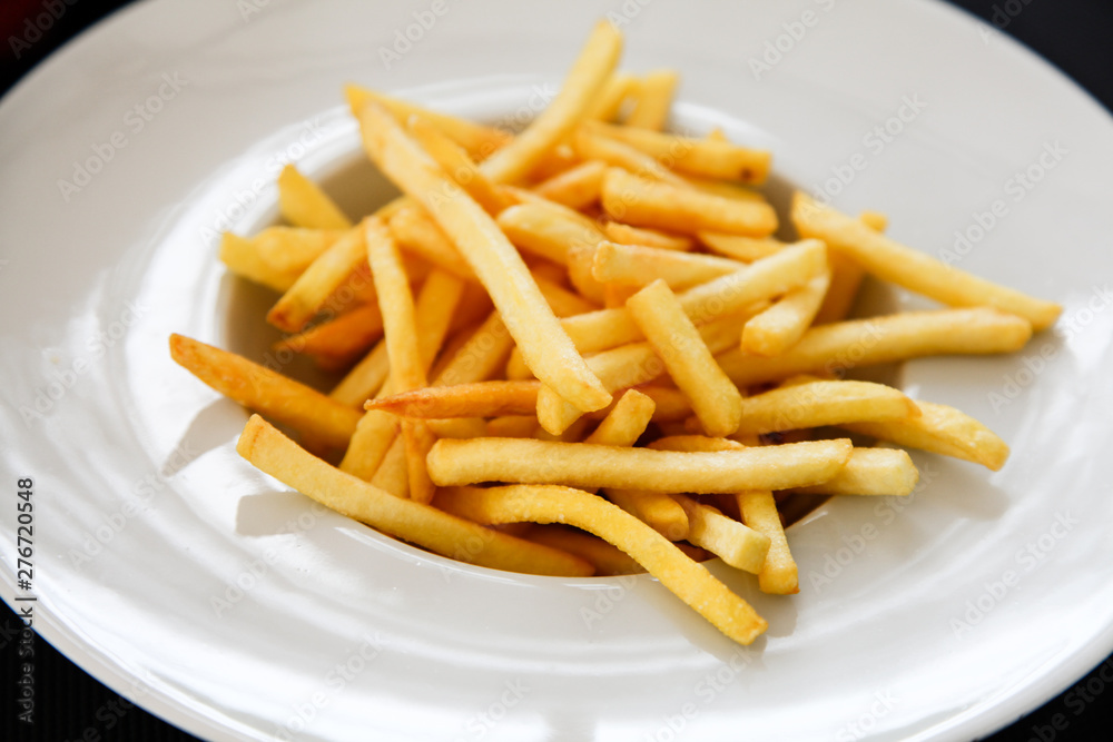 French fries potatoes on a white plate. French fries potatoes on a white plate.