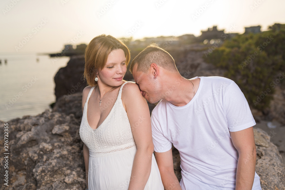 Happy young couple pregnant on the beach at sunset. Happy young couple pregnant on the beach at sunset.