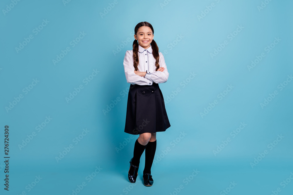 Full size photo of lovely child feel glad standing looking isolated over blue background Full size photo of lovely child feel glad standing looking isolated over blue background