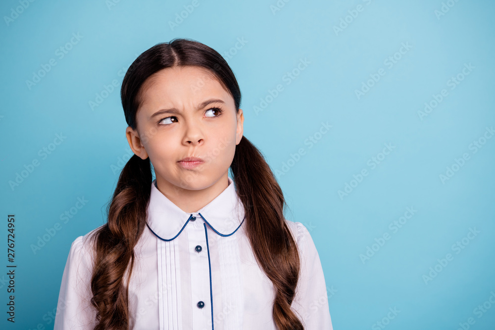 Portrait of pensive kid looking having thoughts wearing white blouse isolated over blue background Portrait of pensive kid looking having thoughts wearing white blouse isolated over blue background