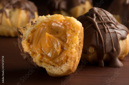 Traditional type of Brazilian profiterolis bakery candy called carolina in wood background with one open