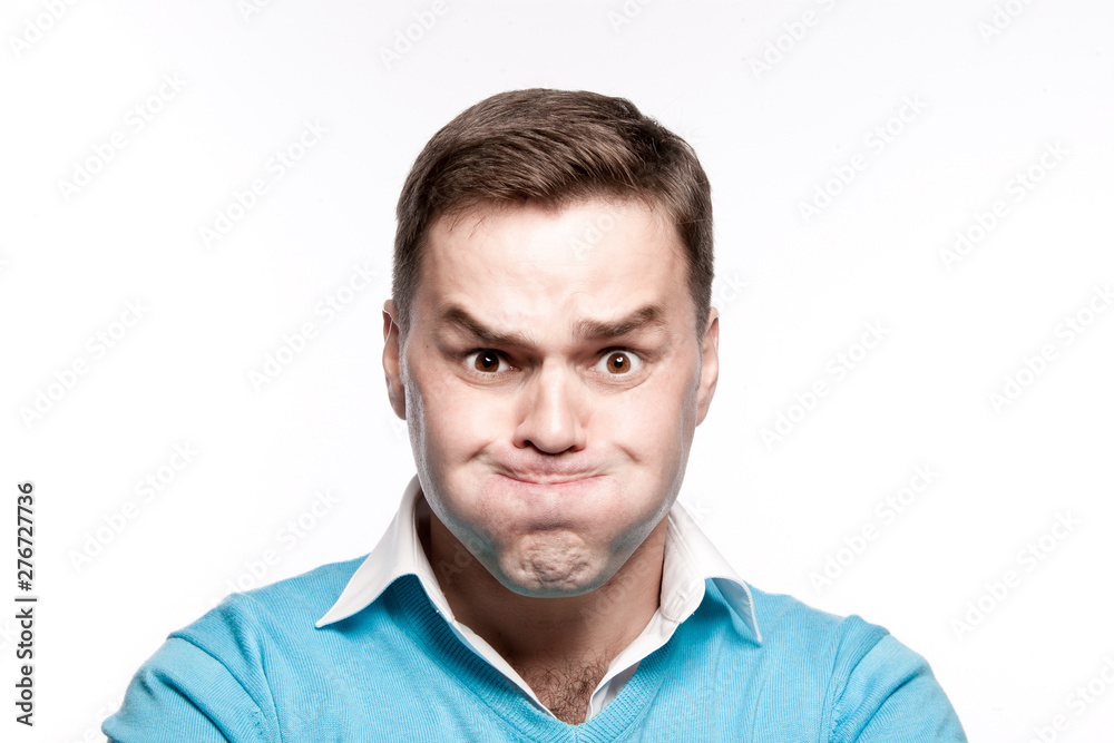 A young man with pouty cheeks. On a white background in the studio.