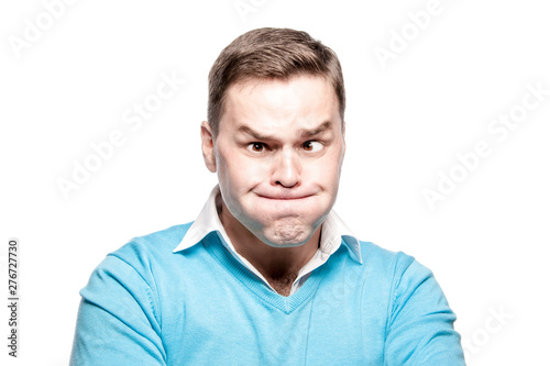 Funny young man with pouty cheeks. On a white background in the studio.