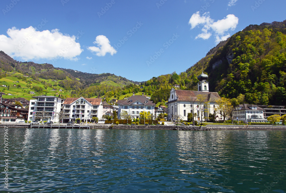 Idyllic Swiss village of Gersau, Canton Schwyz, on Lake Lucerne. Beautiful summer day, Buildings reflected in the water.