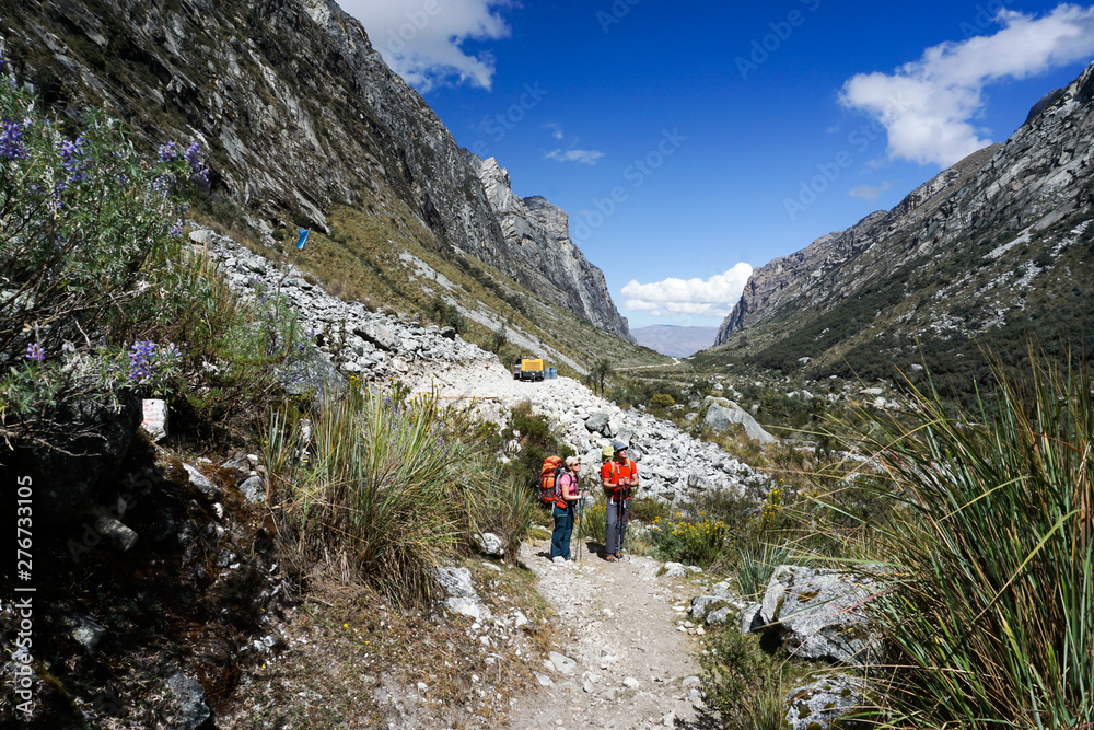 man and woman backpacker in the Andes of Peru return from the remote wilderness back to civilization at a modern road head