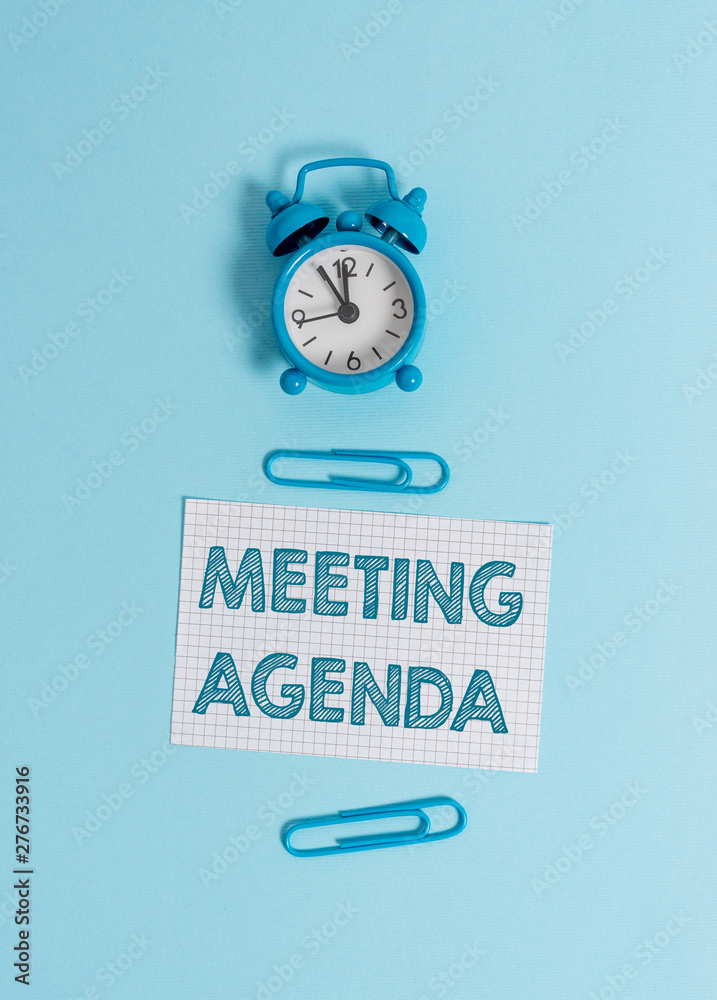 Handwriting text writing Meeting Agenda. Conceptual photo items that participants hope to accomplish at a meeting Alarm clock wakeup squared blank paper sheet clips colored background