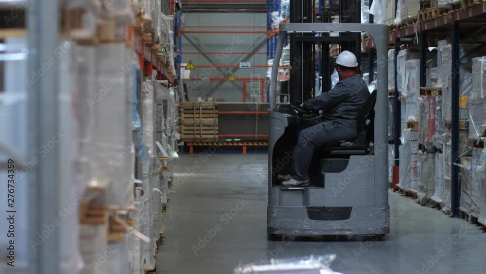 Warehouse worker riding a forklift. 4K Slow Mo Warehouse worker riding a forklift. 4K Slow Mo