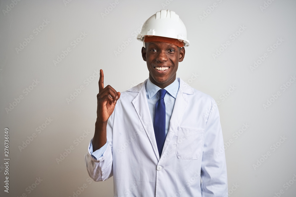 African american engineer man wearing coat and helmet over isolated white background pointing finger up with successful idea. Exited and happy. Number one. African american engineer man wearing coat and helmet over isolated white background pointing finger up with successful idea. Exited and happy. Number one.