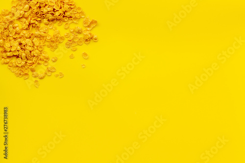 cereals, oatflakes and cornflakes for healthy breakfast on yellow background top view mock up © 279photo