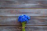 Summer flowers pattern with bouquet of blue cornflowers on wooden background top view mock up