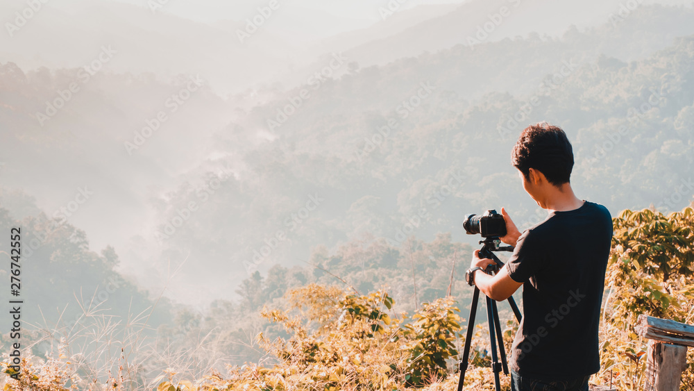 web banner and panorama of earth day and environment care travel concept from photographer man during take photo beautiful landscape of tropical forest with haze with soft focus of layer mountain 
