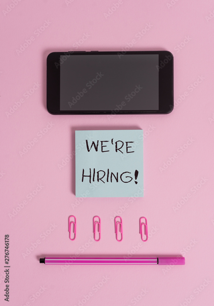 Conceptual hand writing showing We Re Hiring. Concept meaning process of reviewing applications and finding candidates Colored sticky note clips smartphone pen pastel background Conceptual hand writing showing We Re Hiring. Concept meaning process of reviewing applications and finding candidates Colored sticky note clips smartphone pen pastel background