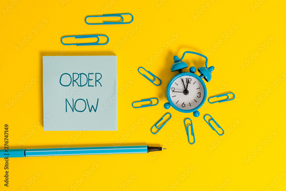Word writing text Order Now. Business photo showcasing the activity of asking for goods or services from a company Metal alarm clock wakeup clips ballpoint notepad colored background