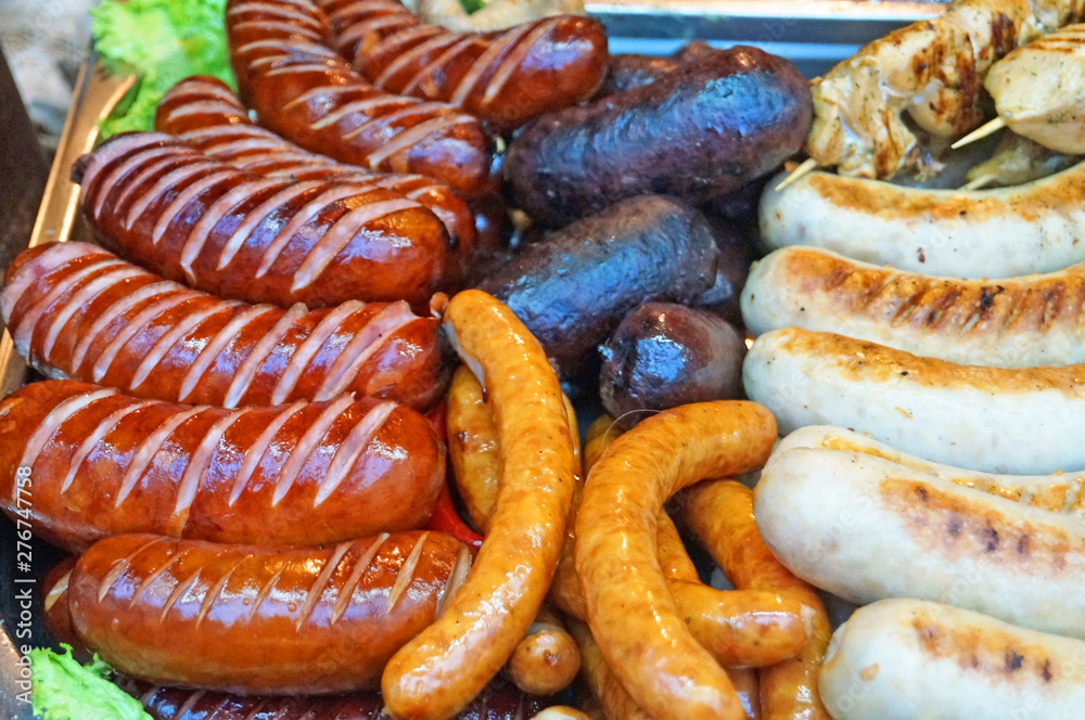 Grilled sausages, homemade sausages and kupaty on the counter at the fair on a sunny day Grilled sausages, homemade sausages and kupaty on the counter at the fair on a sunny day