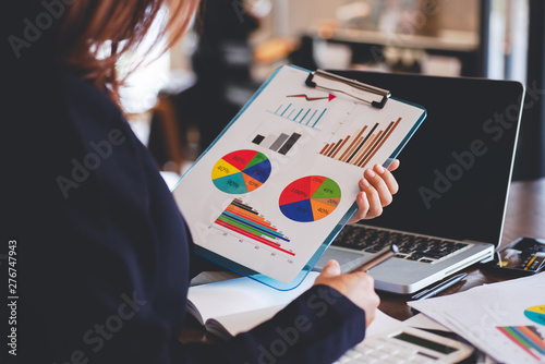 business person holding a file documents in the hand ,Businesswomen work in office using a laptop computer, job analysis and job description checking