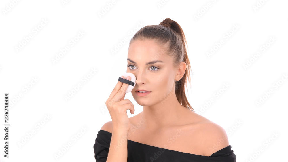 Beauty concept. The woman is using a sponge to apply powder on her face. Beauty concept. The woman is using a sponge to apply powder on her face.