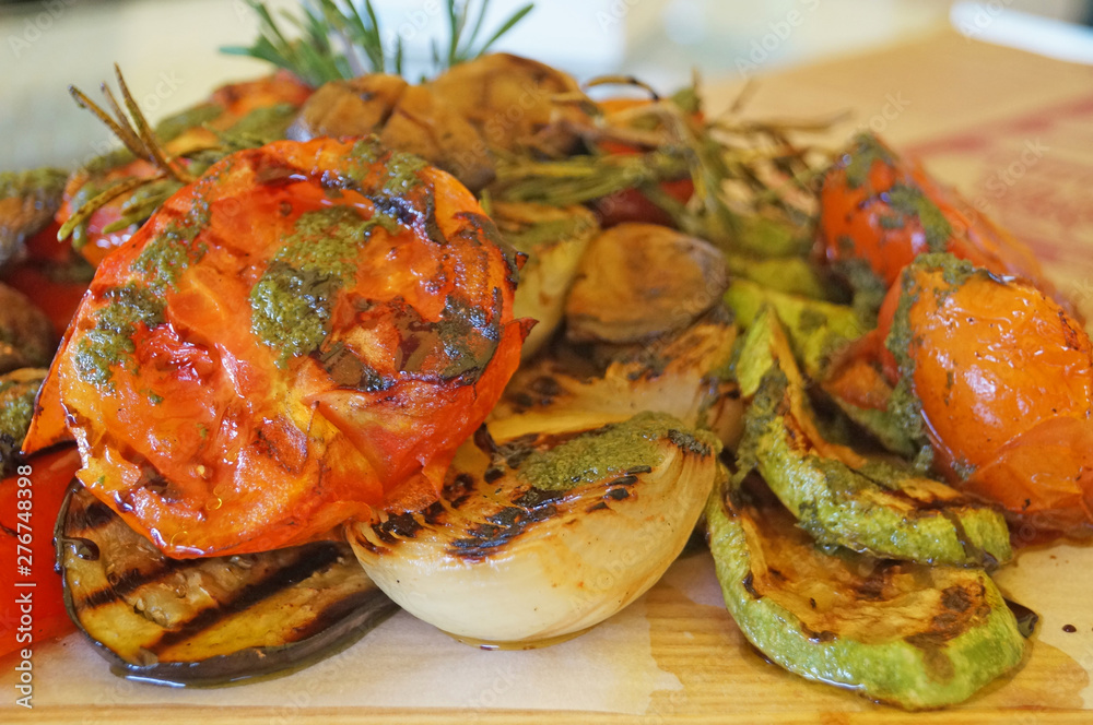 Tomato, zucchini, onions and eggplant grilled and decorated with rosemary on a plate on the table Tomato, zucchini, onions and eggplant grilled and decorated with rosemary on a plate on the table