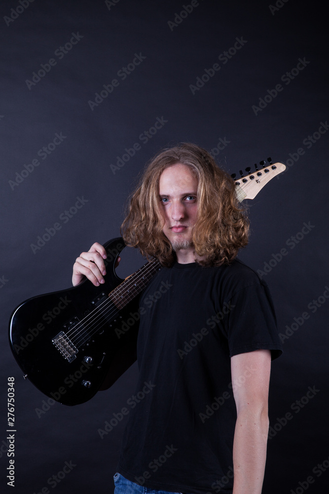 Young caucasian adult with long hair playing guitar