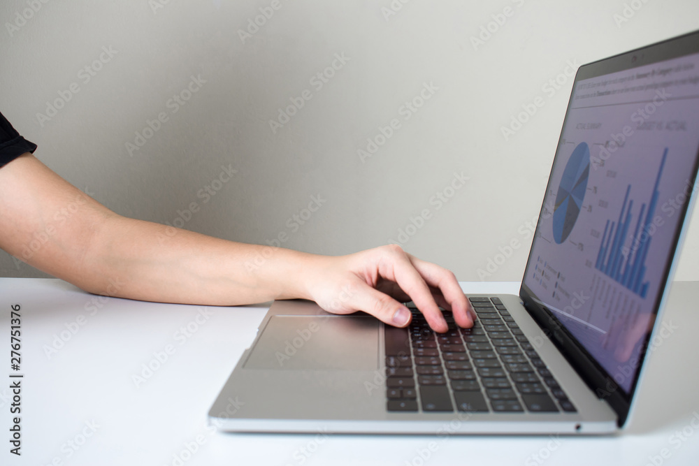 Asian people use a laptop computer on a wooden table. Gray background. Asian people use a laptop computer on a wooden table. Gray background.