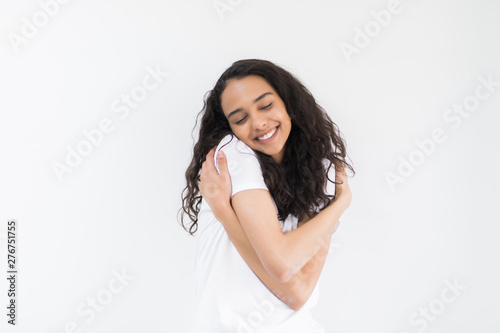 Portrait with copy space, empty place of sensual cute girl embracing herself with two crossed hands close eyes isolated on white background