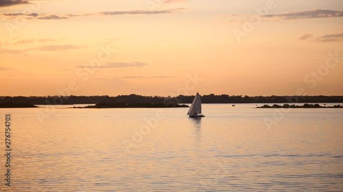 Sailing boat at sea at sunset. Beautiful sunset on the river. Beautiful sunset on the river. Seagulls fly in the rays of the setting sun