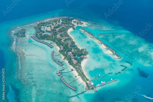Scenery above the blue ocean from airplane window Maldives island