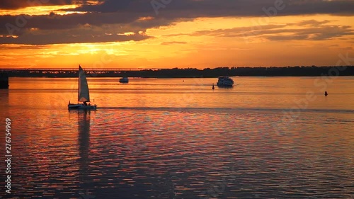Sailing boat at sea at sunset. Beautiful sunset on the river. Beautiful sunset on the river. Seagulls fly in the rays of the setting sun